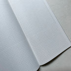 Open notebook with grid paper on a light gray surface