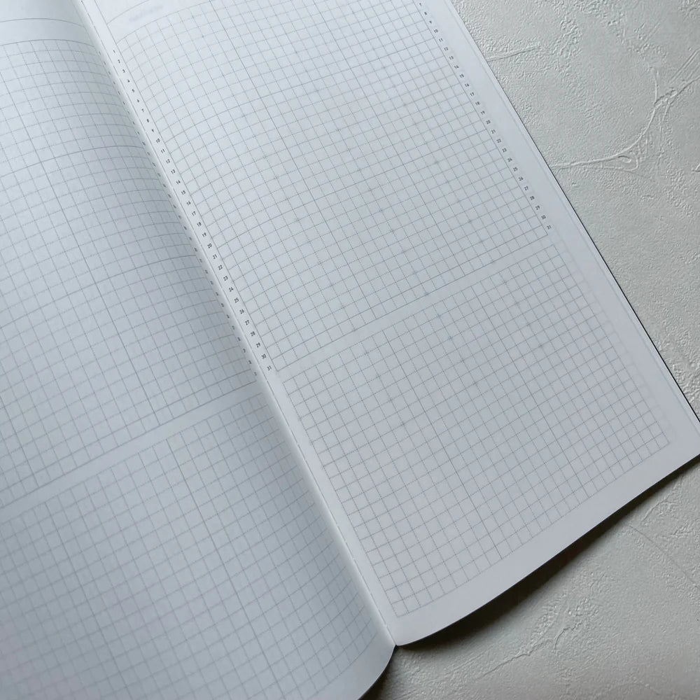Close view of the Take A Note Slim Weekly Planner open grid spread on light grey