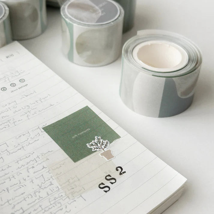 Rolls of decorative tape on a notebook with a tree design