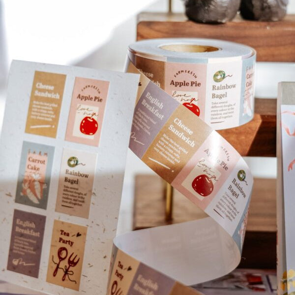 Rolls of paper with printed labels on a wooden surface