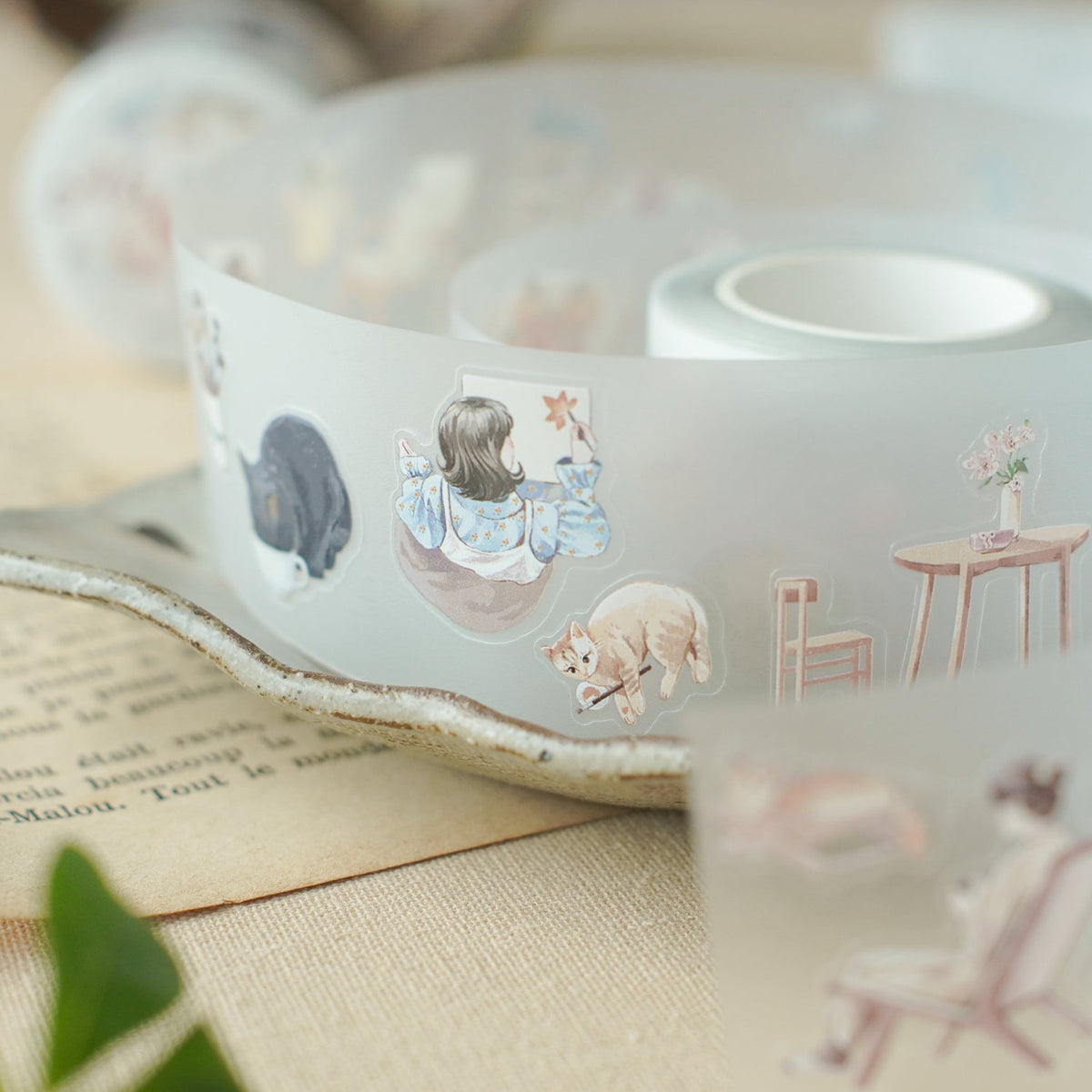 Roll of Aki No Heya PET Tape by Teayou partially unrolled to show its illustrations, close-up
