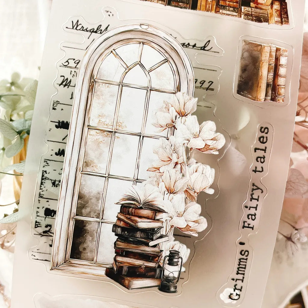 The Cosy Chapter PET Tape die-cut window design with books and flowers on a white surface