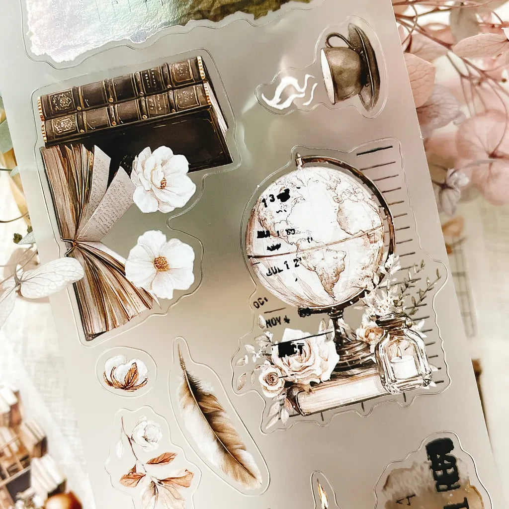 The Cosy Chapter PET Tape globe, book and flower stickers arranged on a white background