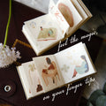 Small illustrated books on a dark surface with text 'feel the magic on your fingertips'.