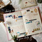 Open daily journal with illustrations and text on a wooden surface.