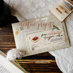 Card with decorative text and illustrations on a wooden surface with lace fabric