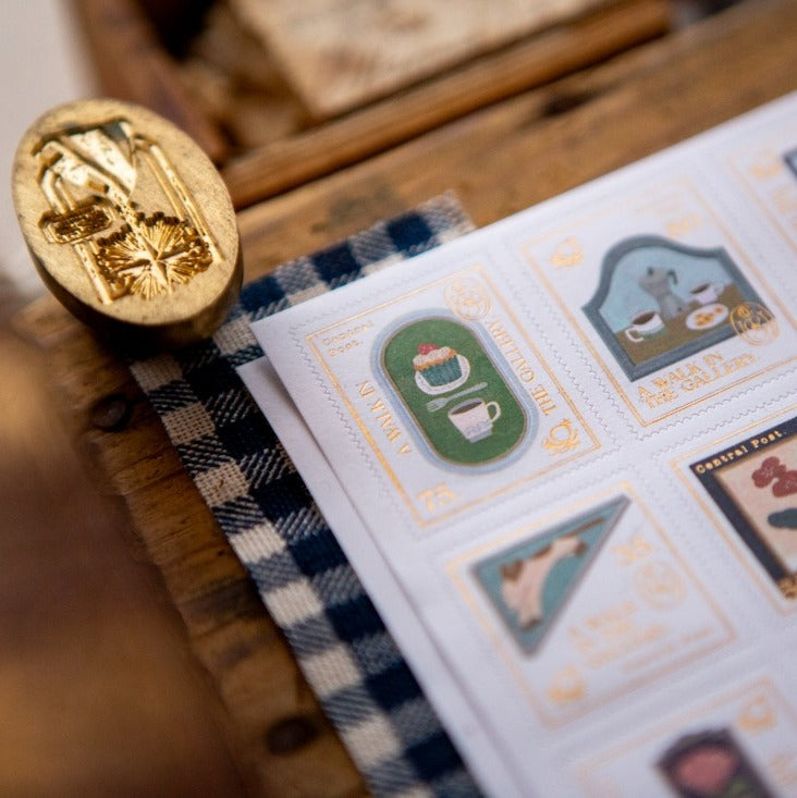 The Gallery Stamp Sticker Sheet by OURS Studio — gold-accent stamp sticker sheet on wood, for journaling