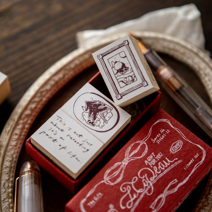 Red rubber stamp set with decorative designs and text on a wooden surface.