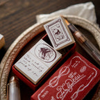 Red rubber stamp set with decorative designs and text on a wooden surface.