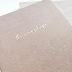 Beige textured notebook cover with subtle grain finish and elegant script title “the memory keeper”