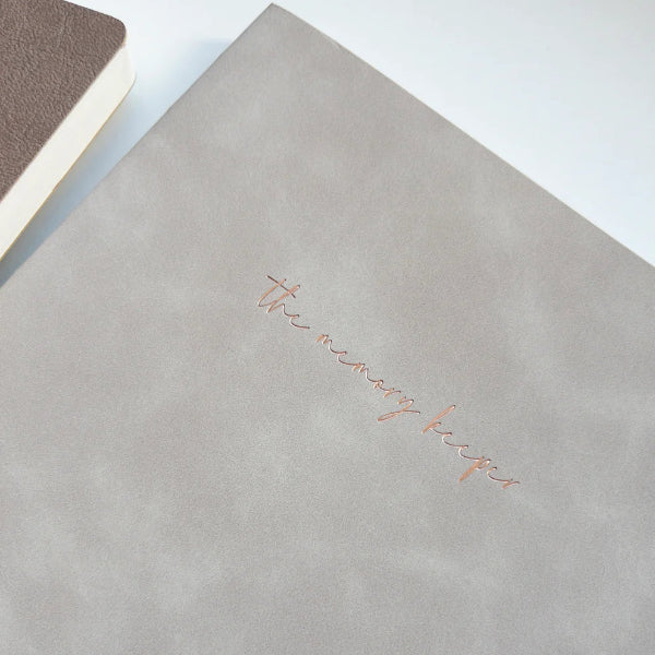 The Memory Keeper A5 Undated Journal in a neutral tone with gold foil title, minimal flat lay