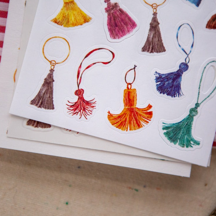 The Tassel Sticker Pack tassel illustrations on a single card with striped fabric behind