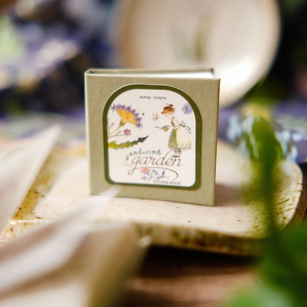 Small book titled 'Gardening Garden' on a wooden surface with a blurred background