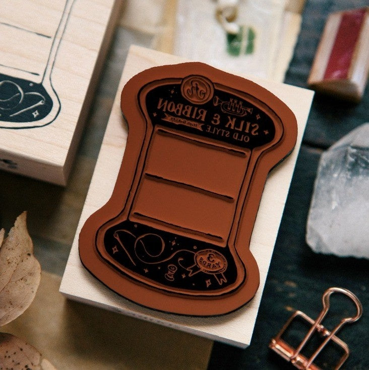 Thread Card Rubber Stamp on its wooden block against a softly blurred background