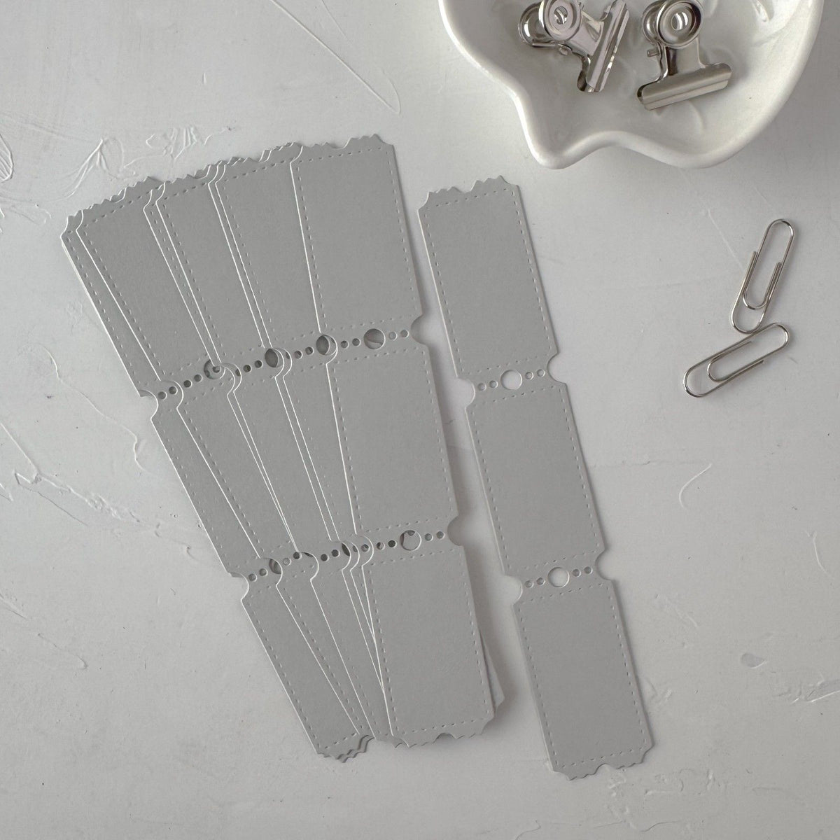 Full set of grey Ticket Card Vol. 1 scalloped-edge cards on a light grey surface