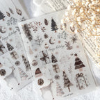 Set of Christmas-themed stickers with trees, presents, and deer on a white surface.