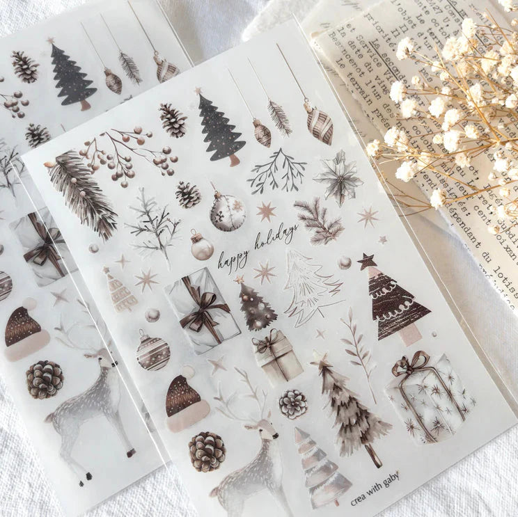 Sheet of Christmas-themed stickers with trees, presents, and deer on a white surface.