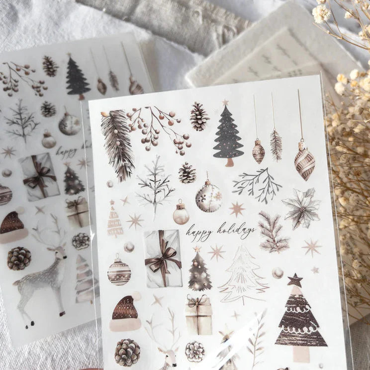 Sheet of decorative stickers with winter-themed designs on a textured surface.