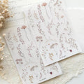Set of floral stickers on a textured surface with dried flowers.