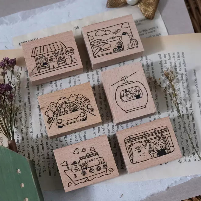 Travel Together Rubber Stamp set by Eileen Tai Studio, six wood-handled stamps arranged on an open vintage book page