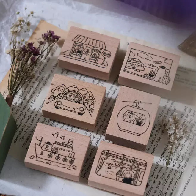 Close-up of Travel Together wood-handled rubber stamps styled with dried flowers on a textured craft surface