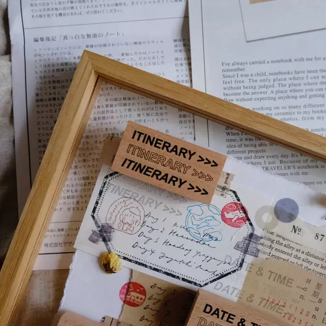 Travel Journaling Series itinerary frame stamp print on a planner page atop a book