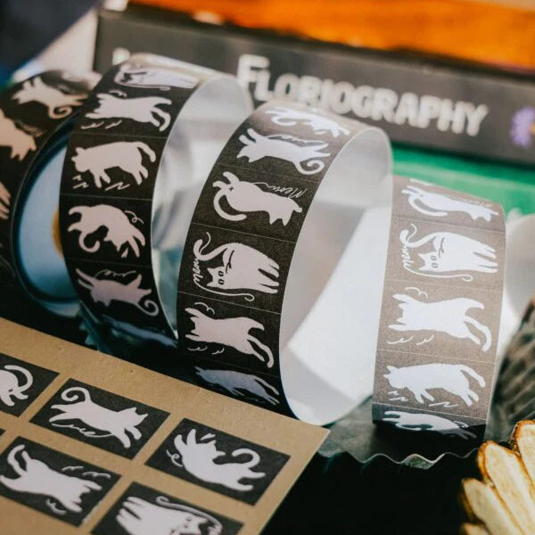 Decorative tape with animal illustrations on a table with 'Floriography' branding.