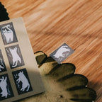 Cat-shaped stamps on a wooden surface with a hand holding a stamp pad.