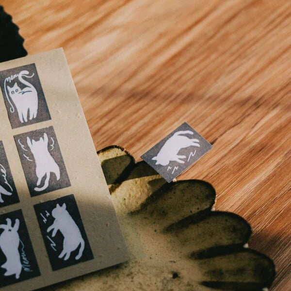 Twisty Cats Label Sticker Tape cat designs on wood with a hand holding a stamp pad