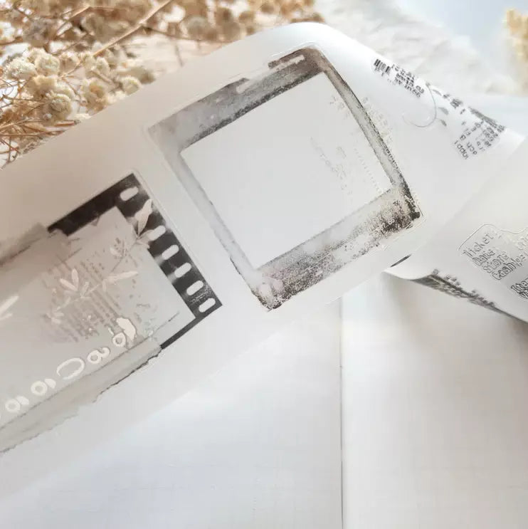 Close-up of the Untold PET Tape film strip negative design laid on a white surface