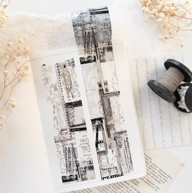 Two black and white Untold Washi Tape strips styled with dried flowers on texture
