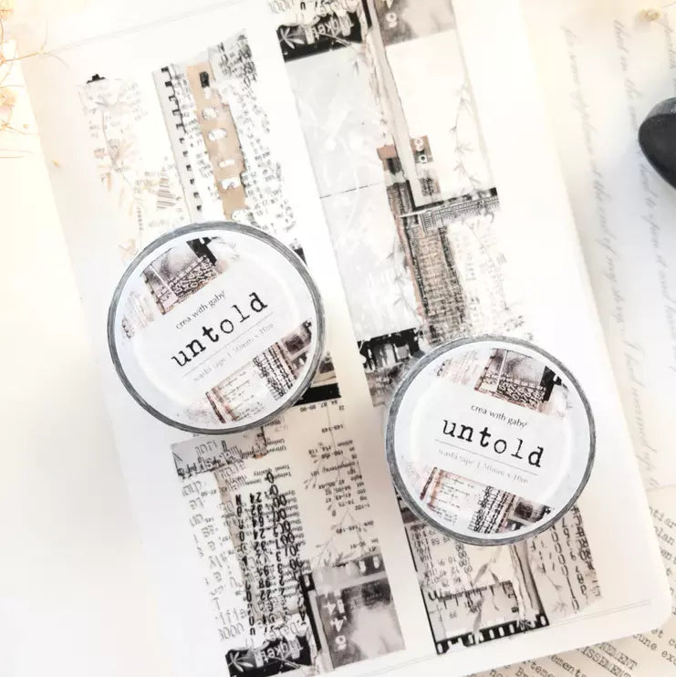 Untold Washi Tape designs artfully styled on two candles with text and artistic elements