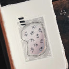 Embroidered patch with black and white design on a white fabric background