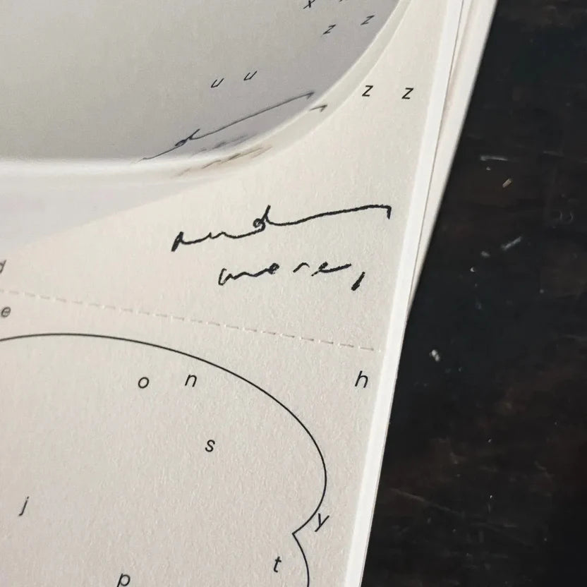 Close-up of a Vintage Hand-Torn Alphabets Memo Pad page with handwritten text on dark