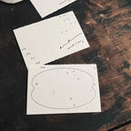 Two sheets of paper with printed letters on a wooden surface