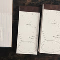 Two open notebooks with text and diagrams on a dark surface