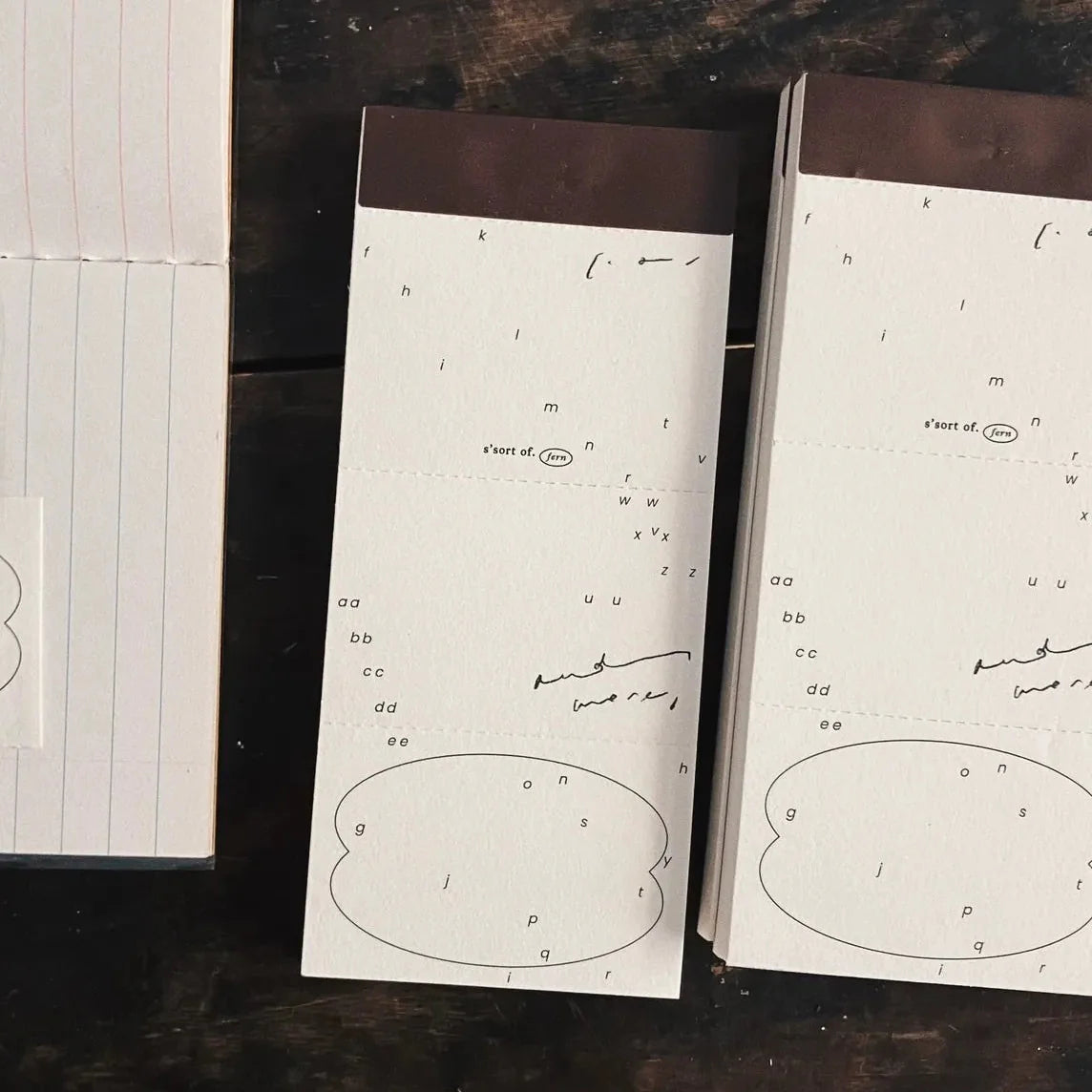 Two open Vintage Hand-Torn Alphabets Memo Pads with text and diagrams on a dark surface