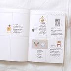 Open book with illustrations and text on a white surface