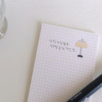Grid notebook with a lamp illustration and Korean text on a light surface