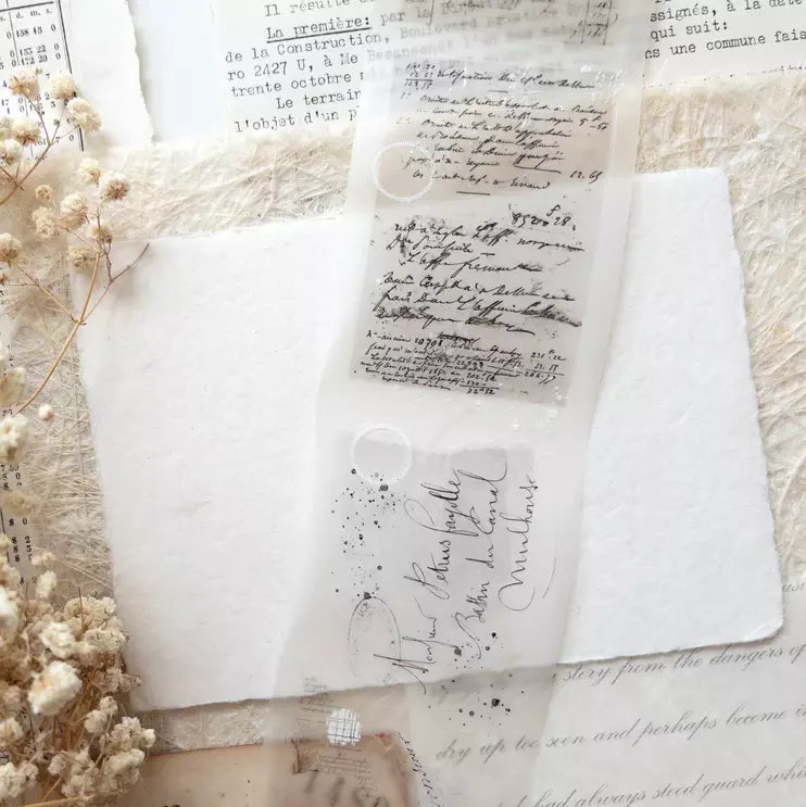 Vintage Layers PET Tape text and floral elements on white fabric on a textured surface