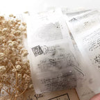 Translucent stickers with vintage text and design on a white background with dried flowers.