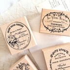 Close-up of wooden rubber stamps featuring floral branch, wreath, and classic French label designs