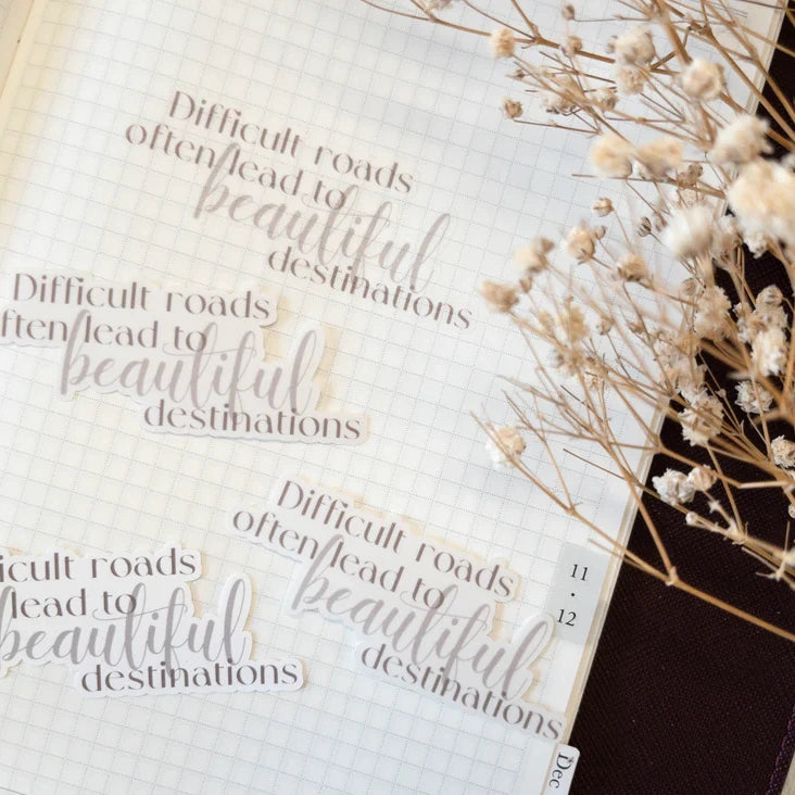 Beautiful Destinations motivational quote sticker on a book with decorative dried flowers