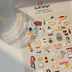 Sheet of Suatelier stickers featuring various illustrations on a plain background