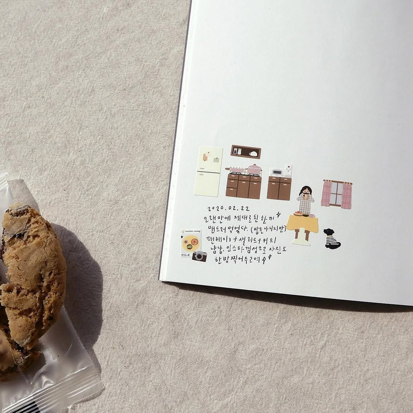 Open book with illustrations on a textured surface, from the Vlog Home Sticker Sheet