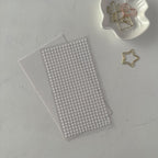 Sheet of small round stickers on a gray surface with decorative paper clips.