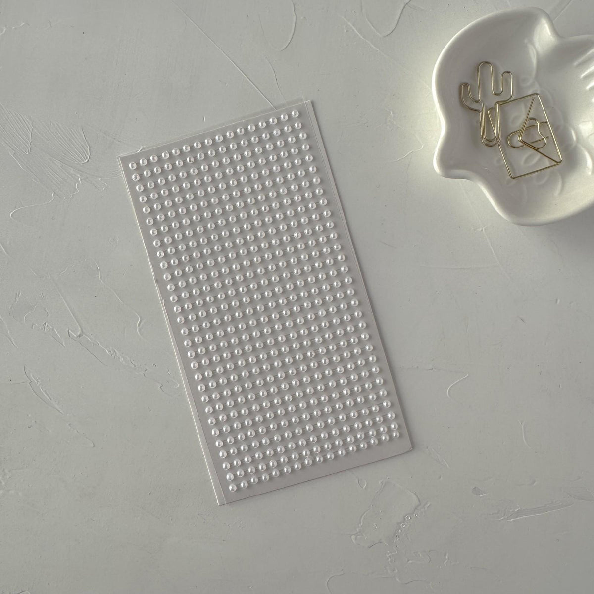 White Pearl Stickers Small sheet on textured grey beside a cactus-design accessory