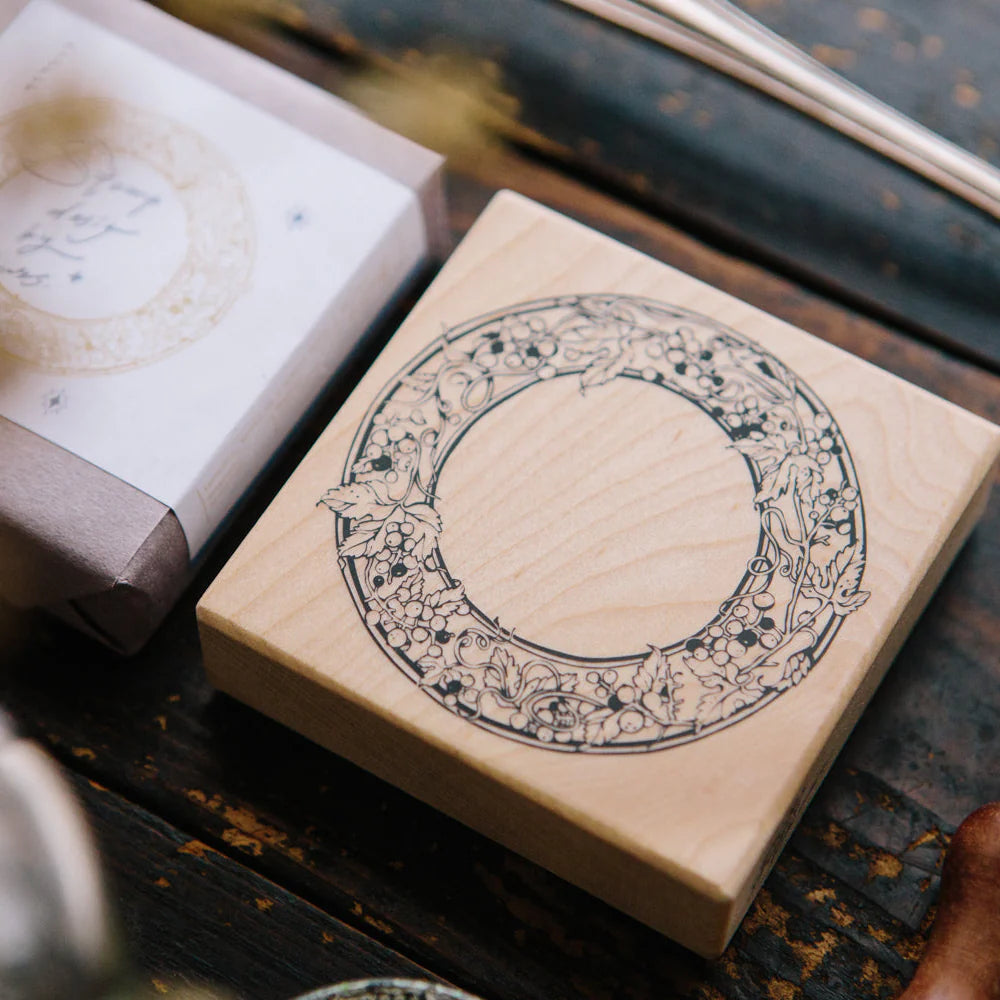 Wild Grape Frame Rubber Stamp wooden block with carved vine design on a wooden surface