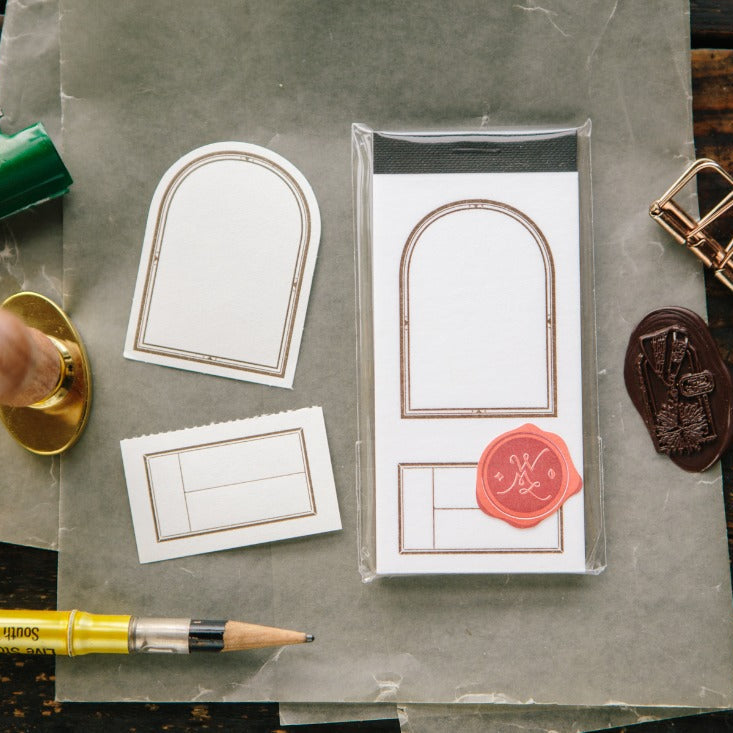 Window Label Letterpress Memo Pad by OURS Studio styled with stamps and tools on a wooden desk