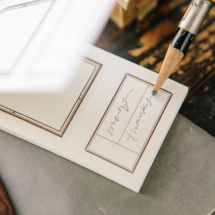 Handwritten note on a Window Label Letterpress Memo Pad sheet with a pen and envelope behind